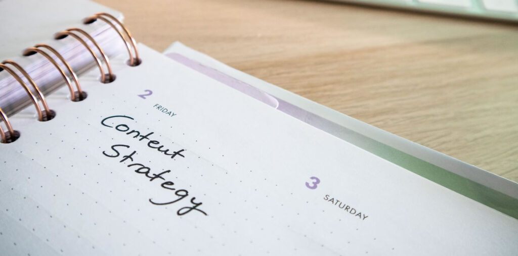 Desk with a planner with the words Content Strategy on it