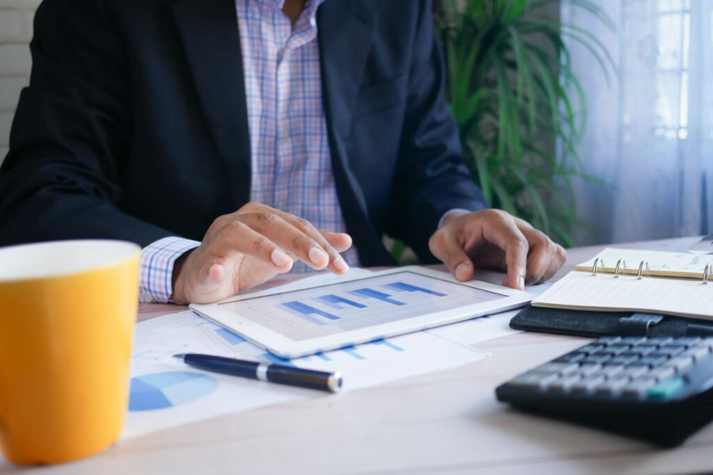 Businessman analyzing financial data on a tablet, focused on charts and graphs for informed decision-making.
